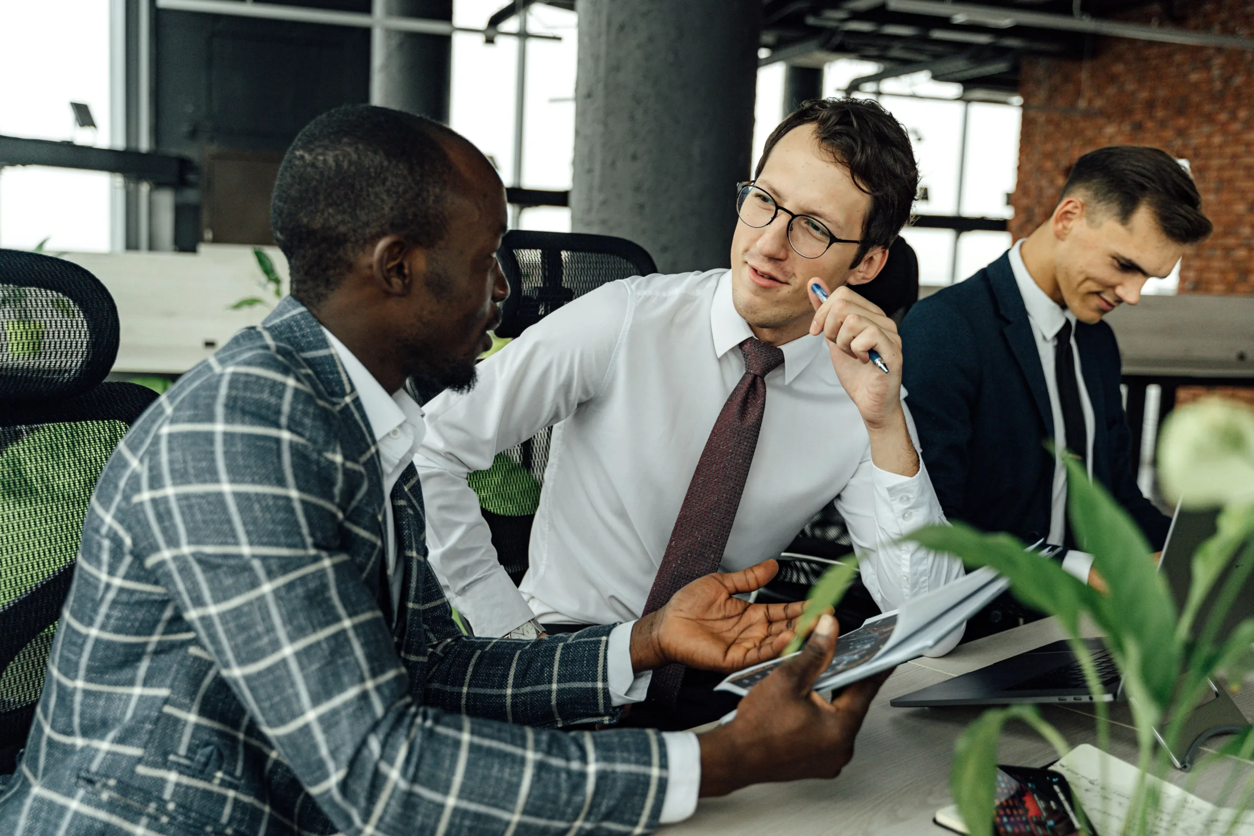 Conseillers bancaires en réunion consultant des documents et un ordinateur portable